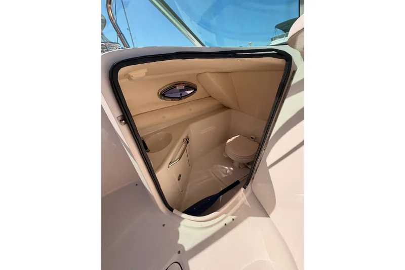 Slide: The Image of 2005 Sea Ray 240 Sundeck interior cabin with compact toilet and window. - 14