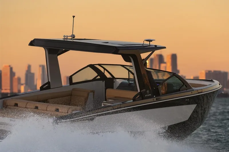 Slide: The Image of Manufacturer Provided Image: 2024 Aviara AV32 I/O boat cruising at sunset with city skyline in the background. - 4