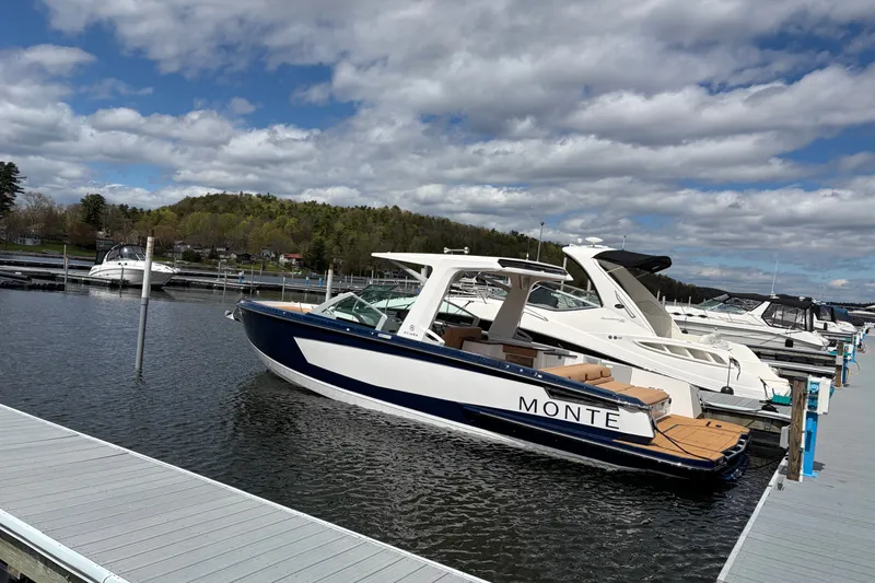 The Image of 2024 Aviara AV32 I/O boat docked at a marina under a partly cloudy sky. - 0