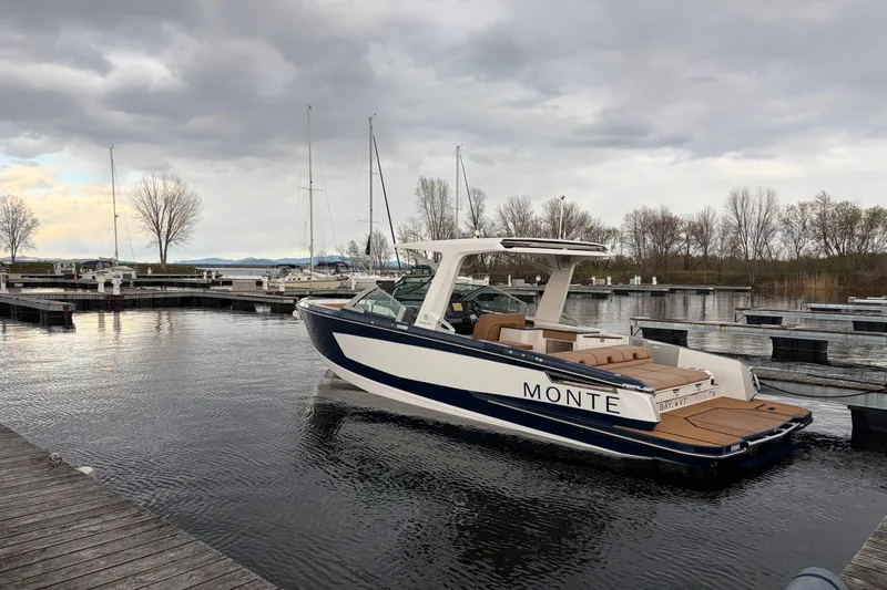 Slide: The Image of 2024 Aviara AV32 I/O boat docked in a serene marina setting. - 3