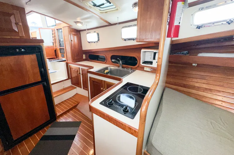 Slide: The Image of 2003 Northern Bay 36 boat interior with kitchen, stove, sink, and wooden cabinetry. - 50