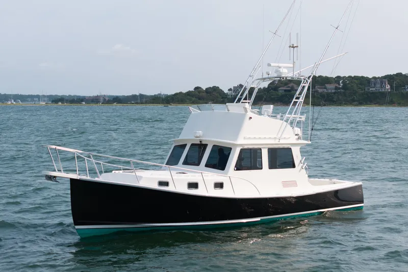 Slide: The Image of 2003 Northern Bay 36 boat on calm water, featuring a sleek black and white design. - 67