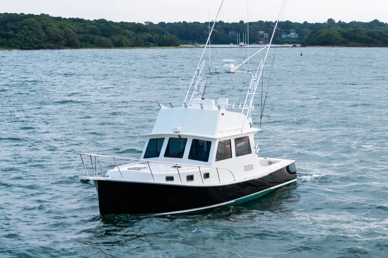 Slide: The Image of 2003 Northern Bay 36 boat cruising on a scenic waterway. - 64