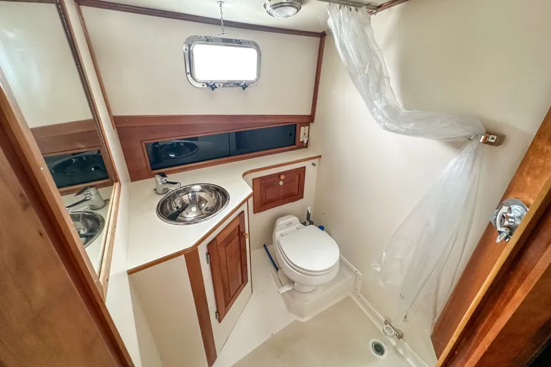 Slide: The Image of Bathroom interior of 2003 Northern Bay 36 boat with sink, toilet, and shower curtain. - 54