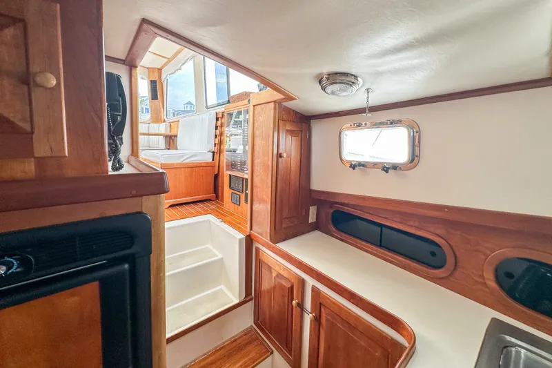 Slide: The Image of Interior of 2003 Northern Bay 36 boat, featuring wood cabinetry and seating area. - 48