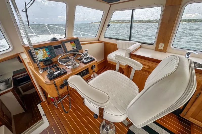 Slide: The Image of Interior helm of 2003 Northern Bay 36 boat with navigation equipment and white seating. - 40