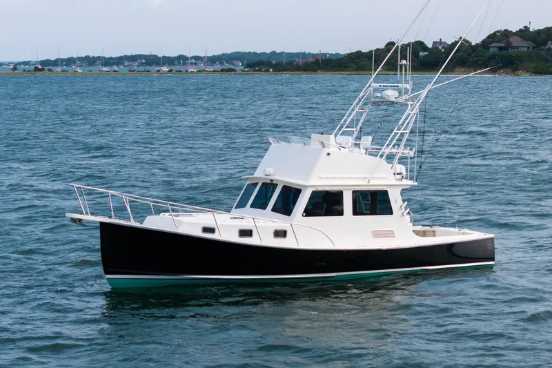 Slide: The Image of 2003 Northern Bay 36 boat on calm water, coastal background. - 63