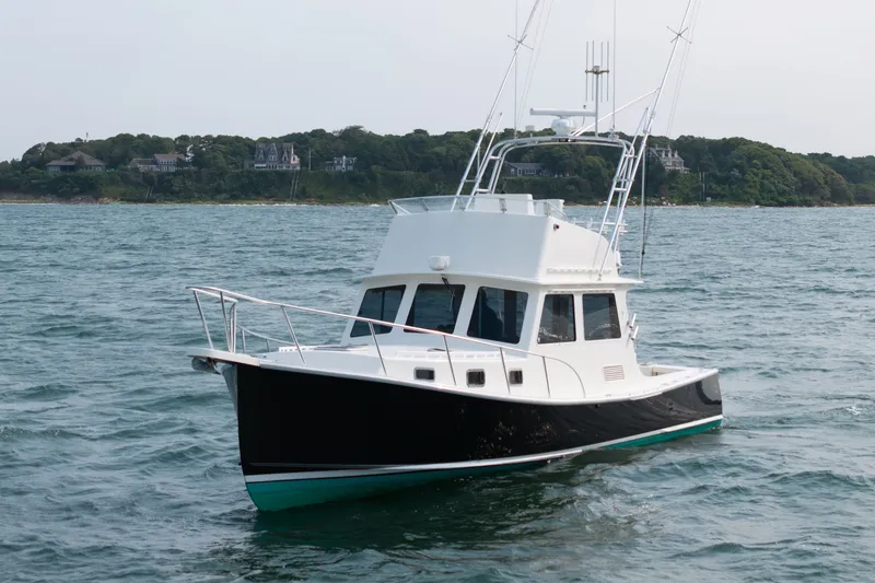 Slide: The Image of 2003 Northern Bay 36 boat on water with coastal background. - 65