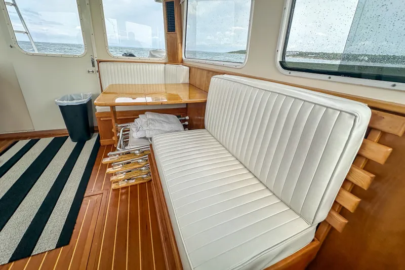 Slide: The Image of Interior of 2003 Northern Bay 36 boat with white seating and wooden table. - 36