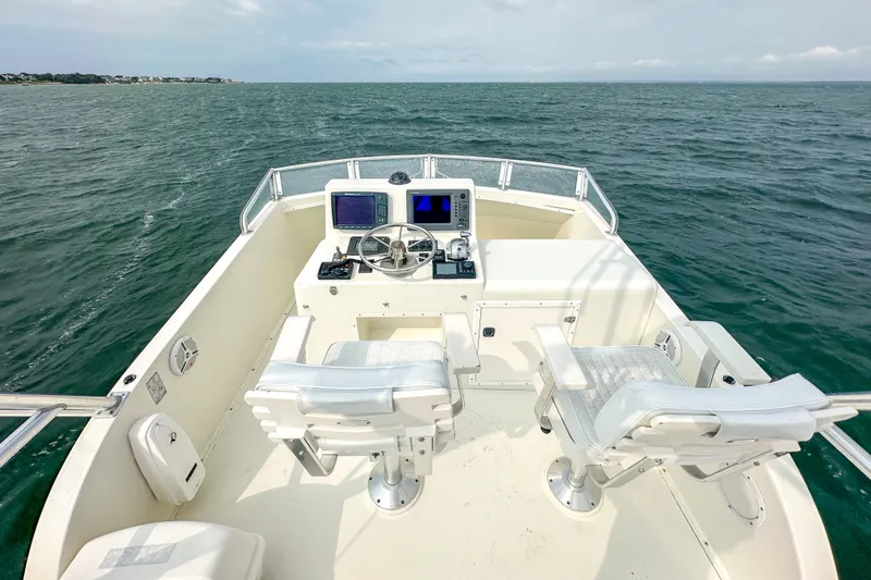 Slide: The Image of 2003 Northern Bay 36 boat helm with dual seats, steering wheel, and navigation equipment on open water. - 25