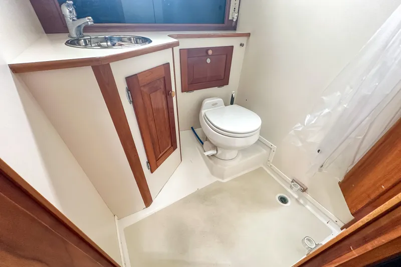 Slide: The Image of Compact bathroom in 2003 Northern Bay 36 boat with sink, toilet, and shower area. - 55