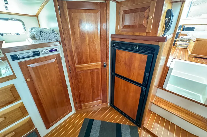 Slide: The Image of Interior of 2003 Northern Bay 36 boat with wooden cabinetry and compact refrigerator. - 47
