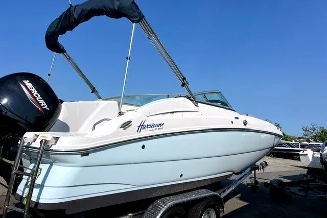 The Image of 2017 Hurricane SunDeck 2200 OB boat on trailer, featuring a Mercury outboard motor. - 0