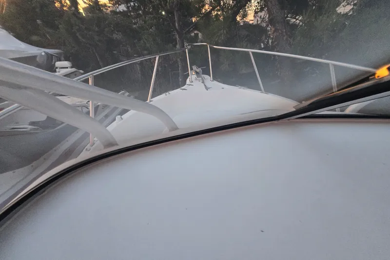 Slide: The Image of 1998 Baha Cruisers 240 WAC boat deck view with railing, surrounded by trees. - 15