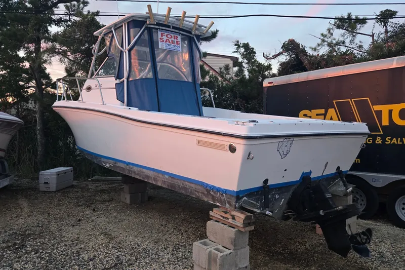 Slide: The Image of 1998 Baha Cruisers 240 WAC boat for sale, elevated on blocks, with blue cover. - 17