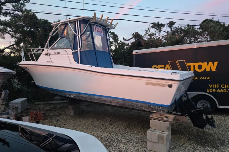 Slide: The Image of 1998 Baha Cruisers 240 WAC boat for sale, elevated on blocks, with blue canopy. - 20
