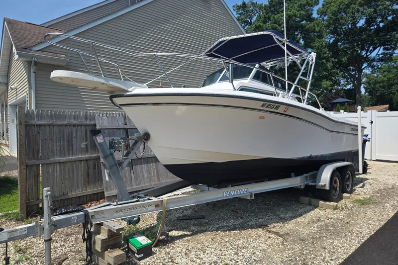 The Image of 1994 Grady-White Adventure 208 boat on trailer, parked beside a house. - 0