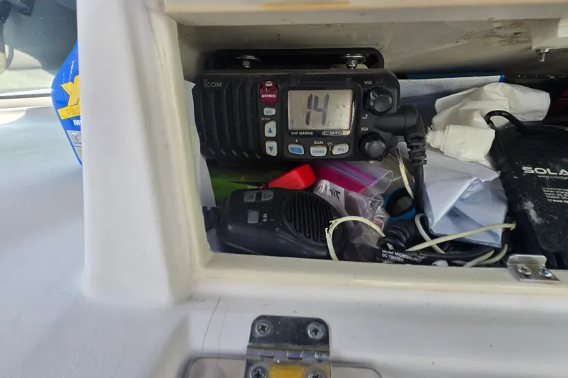 Slide: The Image of VHF marine radio and accessories inside a 1994 Grady-White Adventure 208 boat compartment. - 18