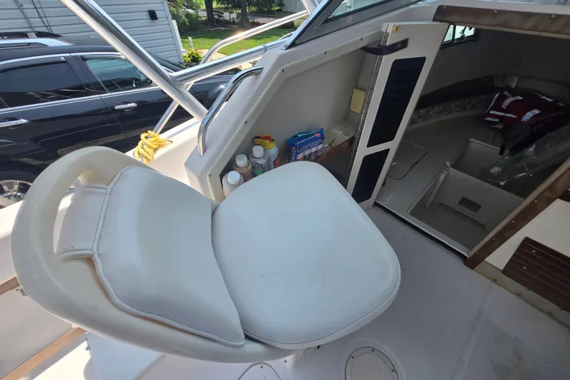 Slide: The Image of 1994 Grady-White Adventure 208 boat interior with white seating and cabin storage. - 13