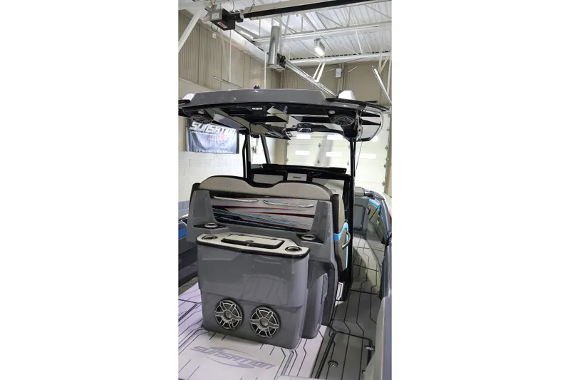Slide: The Image of 2025 Sunsation 32 CCX boat interior with modern seating and audio system in a showroom. - 24
