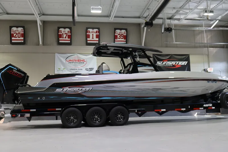 Slide: The Image of 2025 Sunsation 32 CCX boat on trailer in showroom with sports memorabilia. - 3