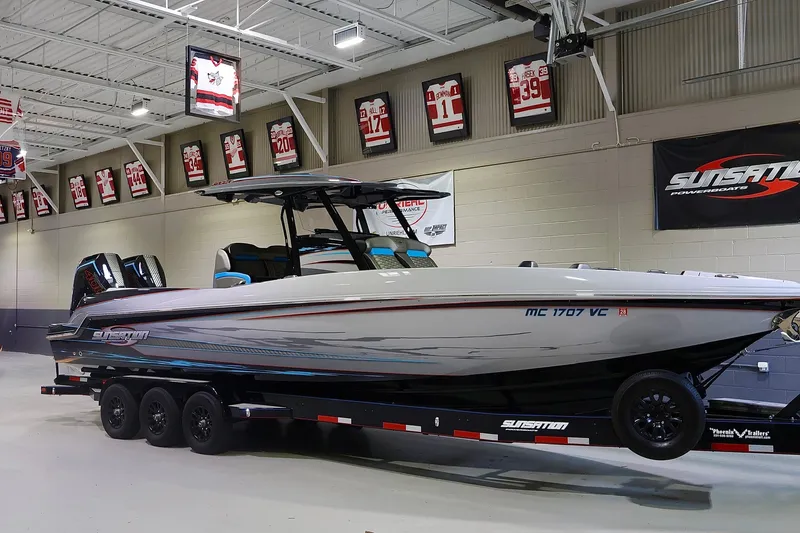 Slide: The Image of 2025 Sunsation 32 CCX powerboat on trailer in indoor showroom with sports memorabilia. - 1