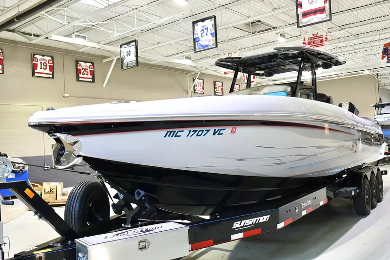 Slide: The Image of 2025 Sunsation 32 CCX boat on trailer in showroom, surrounded by sports memorabilia. - 4