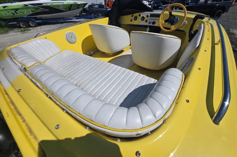 Slide: The Image of Yellow 1994 Donzi 18 Classic boat interior with white seating and steering wheel. - 1