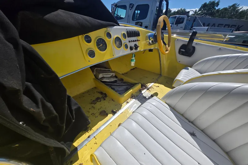Slide: The Image of Interior of a 1994 Donzi 18 Classic boat with yellow dashboard and white seats. - 10