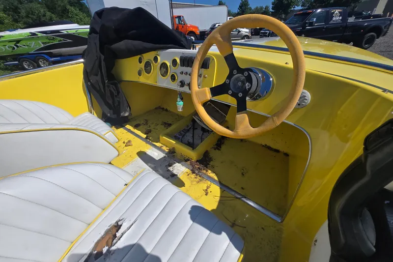 Slide: The Image of 1994 Donzi 18 Classic boat interior with yellow dashboard and white seats. - 11