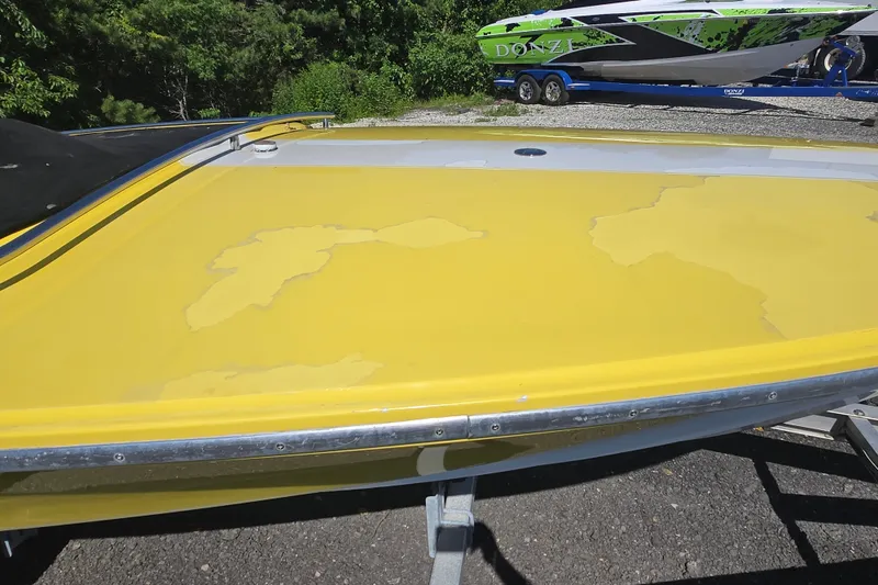 Slide: The Image of Yellow 1994 Donzi 18 Classic boat with peeling paint, parked outdoors. - 12