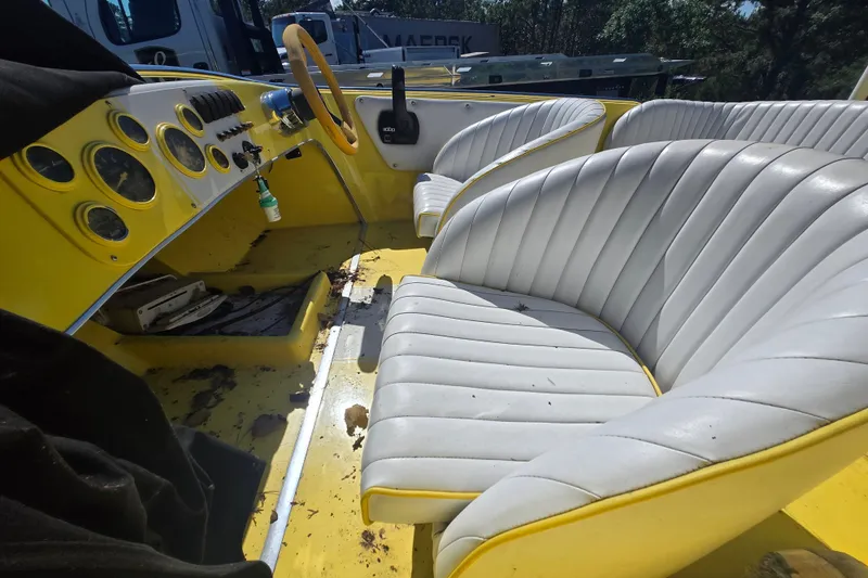 Slide: The Image of Interior of a 1994 Donzi 18 Classic boat with yellow dashboard and white seats. - 9
