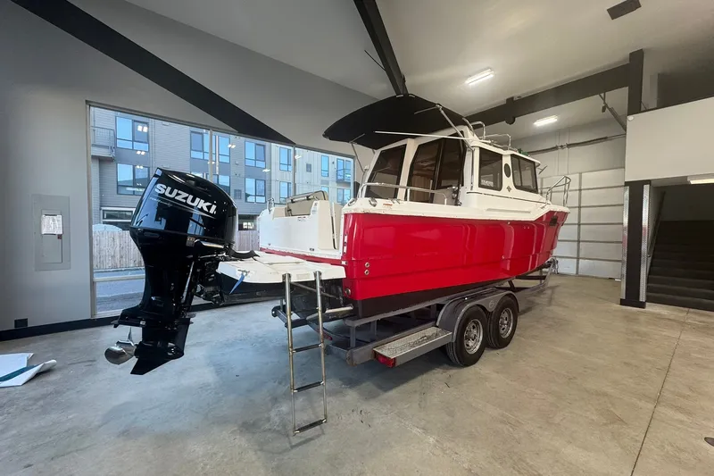 Slide: The Image of 2018 Ranger Tugs R-23 boat with Suzuki outboard motor in a garage. - 1