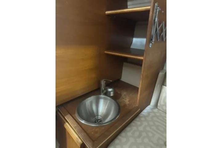 Slide: The Image of 2018 Ranger Tugs R-23 interior with wooden cabinetry and stainless steel sink. - 19
