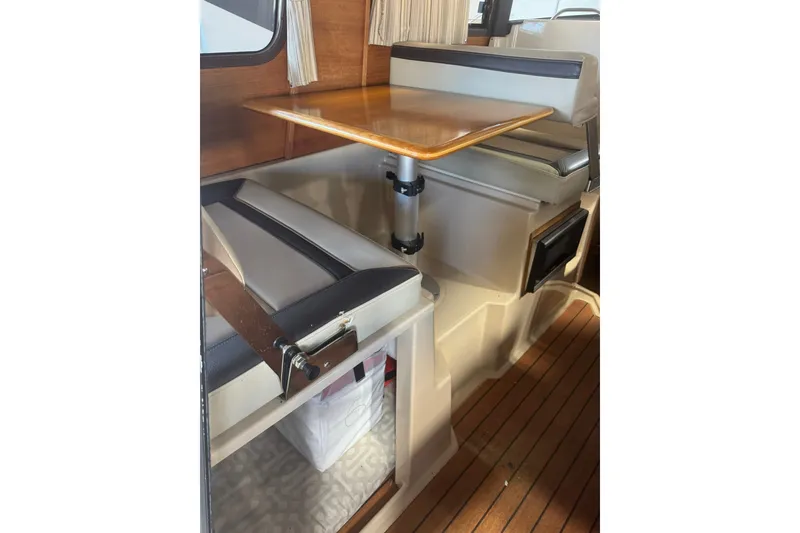 Slide: The Image of Interior of 2018 Ranger Tugs R-23 boat with seating and wooden table. - 12