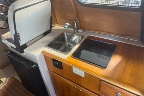 Slide: The Image of 2018 Ranger Tugs R-23 boat interior with compact kitchen, featuring a sink and stove. - 14