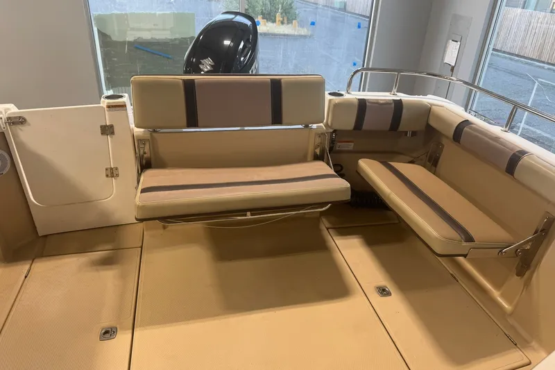 Slide: The Image of 2018 Ranger Tugs R-23 boat interior with beige seating and storage compartments. - 10