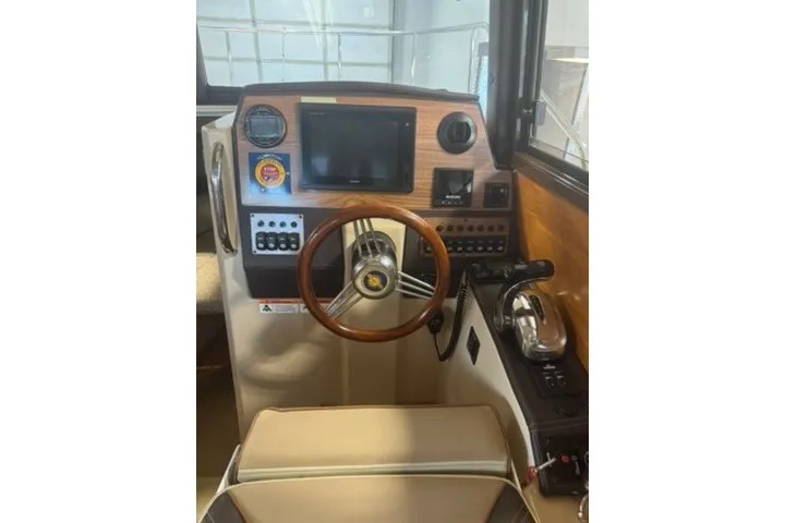 Slide: The Image of 2018 Ranger Tugs R-23 helm with wooden steering wheel and modern controls. - 16