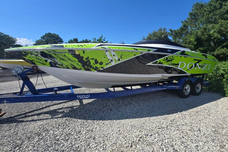 Slide: The Image of 1998 Donzi 28 ZX speedboat with vibrant green and black design on a trailer. - 11