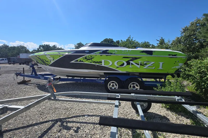 The Image of 1998 Donzi 28 ZX speedboat with vibrant green and black design on a trailer. - 0