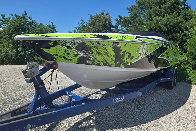 Slide: The Image of 1998 Donzi 28 ZX speedboat with vibrant green and black design on a trailer. - 7