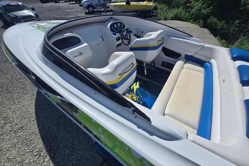 Slide: The Image of 1998 Donzi 28 ZX boat interior with white and blue seating, parked outdoors. - 16