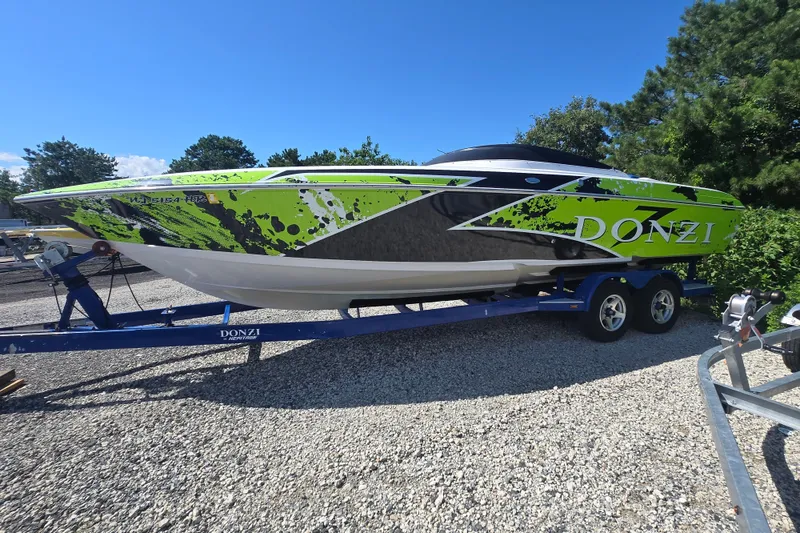 Slide: The Image of 1998 Donzi 28 ZX speedboat with vibrant green and black design on a trailer. - 8