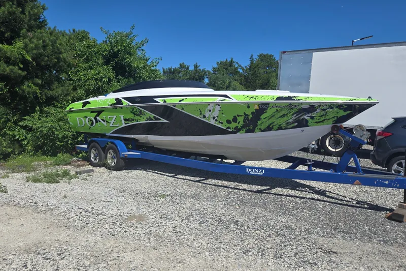 Slide: The Image of 1998 Donzi 28 ZX speedboat with vibrant green and black design on a trailer. - 2