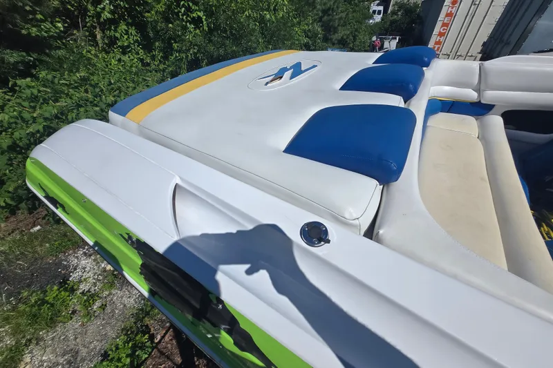 Slide: The Image of 1998 Donzi 28 ZX boat with blue and white seating, docked outdoors. - 12