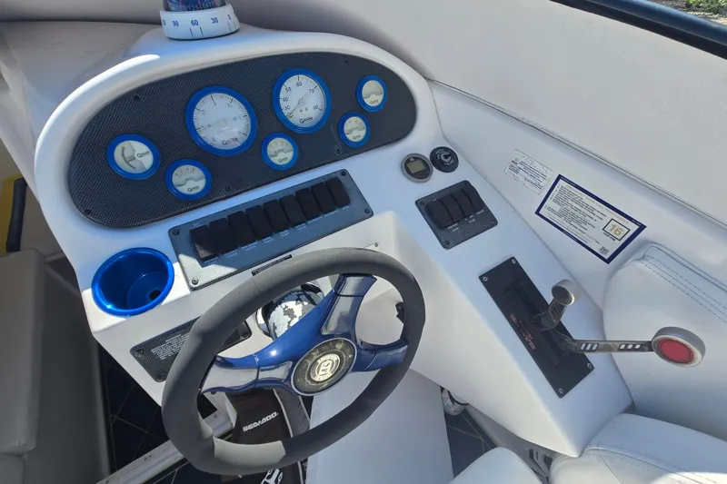 Slide: The Image of 1998 Donzi 28 ZX boat dashboard with gauges, steering wheel, and controls. - 9