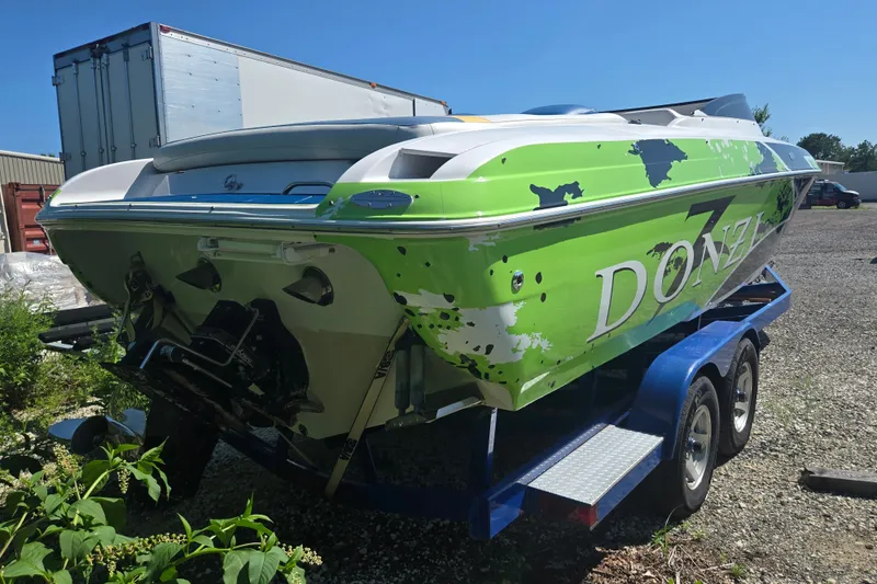 Slide: The Image of 1998 Donzi 28 ZX speedboat with green and white paint on a blue trailer. - 13
