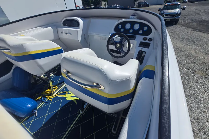 Slide: The Image of 1998 Donzi 28 ZX boat interior with white seats, blue and yellow accents, and dashboard controls. - 15