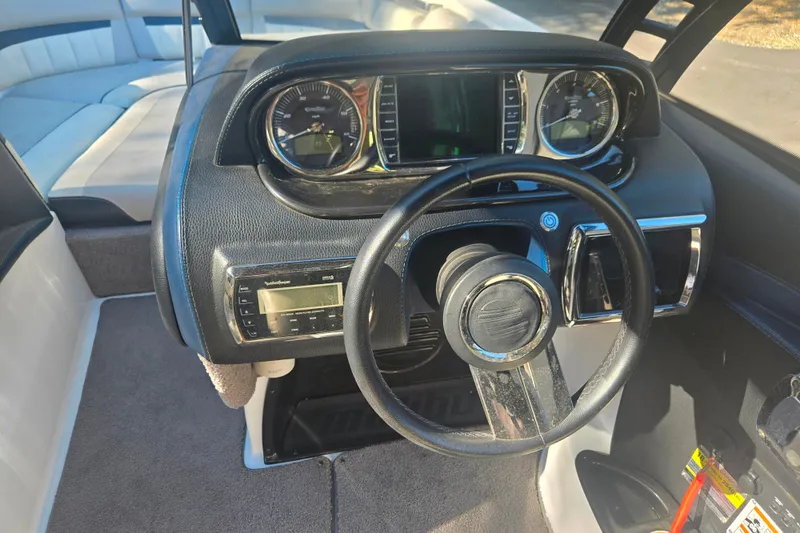 Slide: The Image of Interior dashboard of a 2013 Malibu Wakesetter 24 MXZ boat with steering wheel. - 11