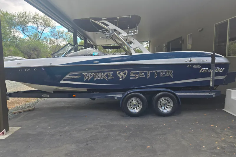 Slide: The Image of 2013 Malibu Wakesetter 24 MXZ boat on trailer under shelter. - 26